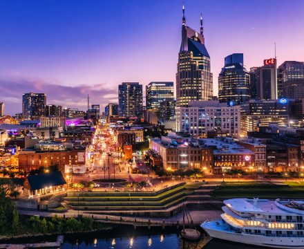 Downtown Nashville skyline glowing at dusk along the riverfront